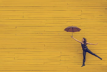 woman, holding, umbrella, jumping, yellow, background, wood, wall, people, girl, lady