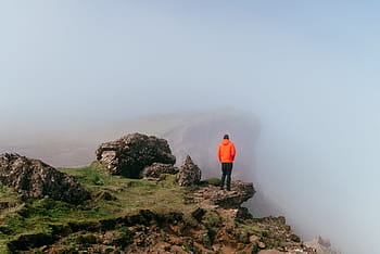 person, standing, mountain, top, daytime, wearing, orange, cliff, people, man, alone