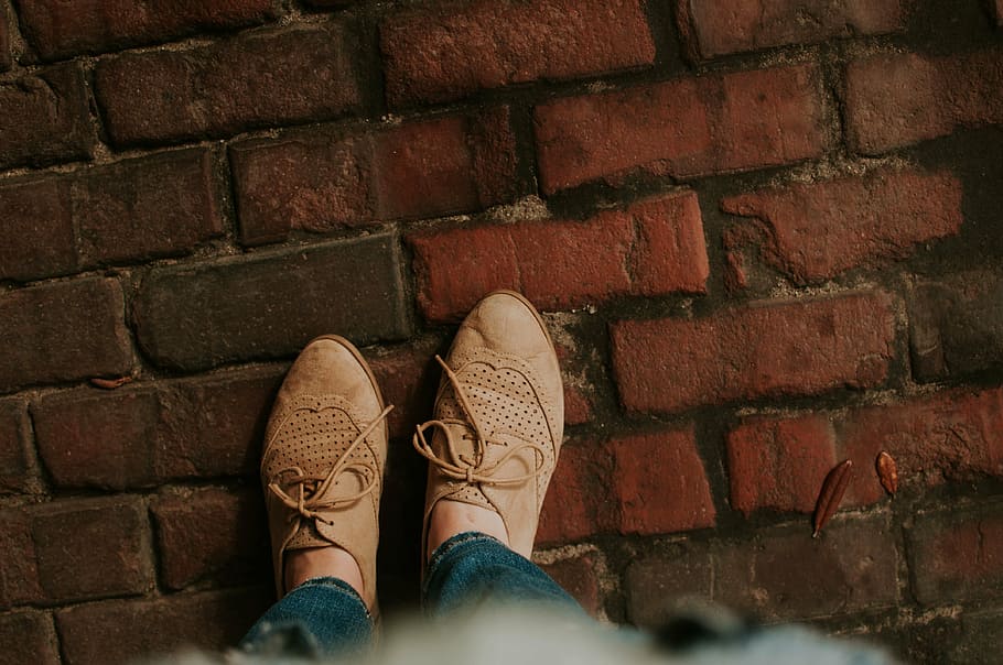 person, stepping, brick ground, people, woman, lady, foot, footwear, shoe, shoe lace, pants