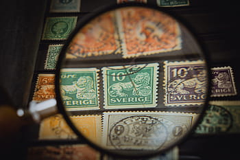 různé barevné poštovní známky, razítka, filatelista, sbírka známek, sběr, sbírka, sklenka, smyčka, zoom, detail, zvědavost