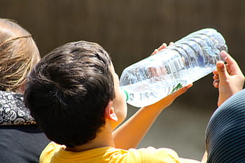 chlapec pít z láhve, dítě pitné vody, žíznivý chlapec pije