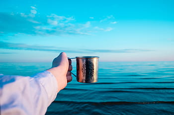 person, holding, stainless, steel mug, ocean, steel, mug, sea, water, waves, nature