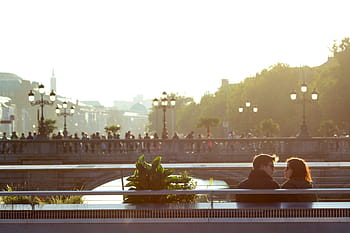 man, woman, sitting, bench, couple, infront, people, bridge, daytime, love, romance