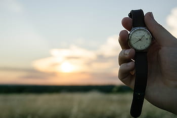 person, holding, round silver-colored analog, watch, outdoors, selective, focus, round, analog, time, hands