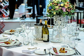 clear, wine glasses, plates, liquor bottles, table, flower centerpiece, dinnerware, set, white, restaurant, setup