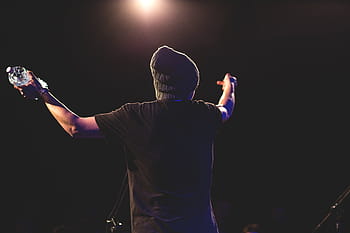 person, holding, plastic bottle, man, wearing, black, crew, neck, shirt, plastic, bottle