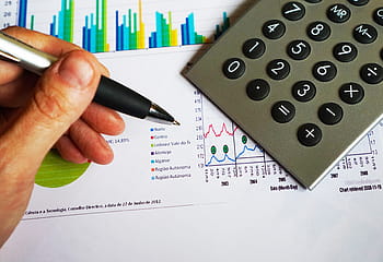 person, holding, silver pen, office, pen, calculator, computation, data, chart, financial, money