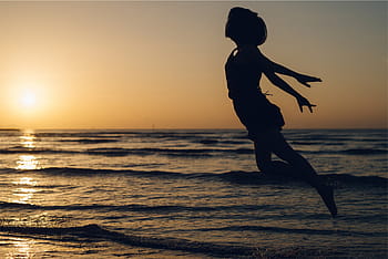 woman, jumping, mid, air, seashore, silhouette, daytime, sunset, dusk, flying, people