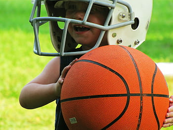 closeup, wearing, nfl helmet, holding, basketball, kid, happy, smiling, fun, young, child