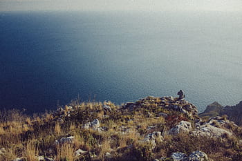 person, standing, cliff, viewing, body, water, cloudy, day, body of water, blue, brown