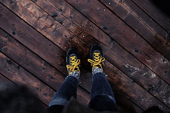 person, wearing, black-and-yellow, sneakers, brown, wooden, floor, man, black, yellow, athletic