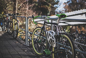 black, green, road bike, parked, gray, metal railing, bike, bicycle, sport, hobby, helmet