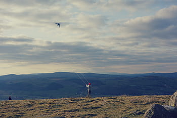 person, playing, kite, flying, cloudy, sky, daytime, highland, grass, mountain, view