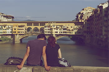 man, woman, sitting, bridge, near, body, water, front, buildings, day, time