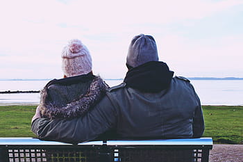 two, people, sitting, outdoor, bench, looking, body, water, daytime, man and woman, body of water
