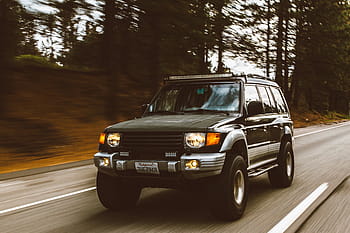 green, silver mitsubishi pajero, road, car, vehicle, headlights, bumper, black, windshield, trees, glossy