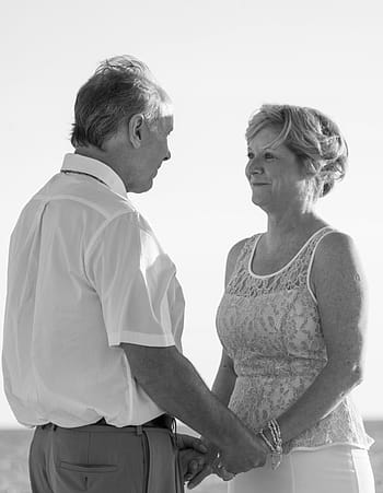 fotografie ve stupních šedi, muž, žena, obložení, hospodářství, ruce, široký, pole, pláž svatba, šťastný pár, západ slunce