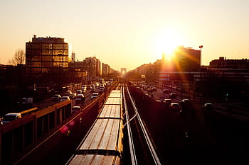 road during sunset, aerial, road, full, cars, sunset, sky, buildings, train tracks, railroad, trucks