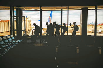 people gathering airport, waiting, area, people, walking, near, glass, window, group, friends, airport