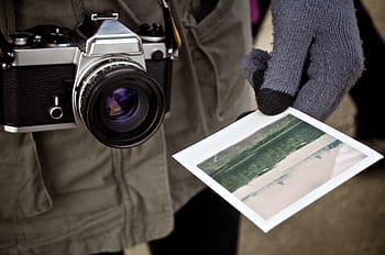 person, holding, landscape photo, gray, black, bridge, camera, paper, print, polaroid, photography