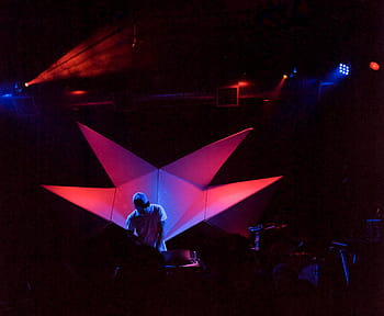 man, standing, stage, red, led, lights, night time, wearing, cap, dj, music