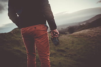 man, holding, camera, standing, grass, person, field, people, male, guy, back