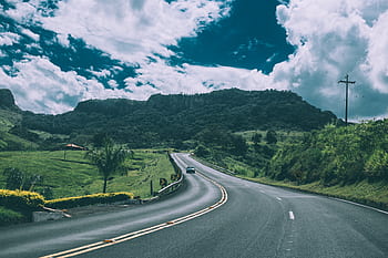 road, highway, cars, driving, green, grass, fields, mountains, hills, sunshine, sky