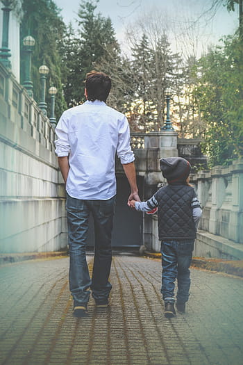 man, white, collared, long-sleeved, shirt, holding, boy, black, leather hooded jacket, walking, green