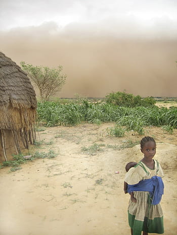 girl, yellow, green, dress, carrying, baby, back, hut, daytime, niger, woman