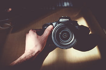 person, holding, black, canon eos camera, camera, lens, accessory, photography, sunlight, wooden, table