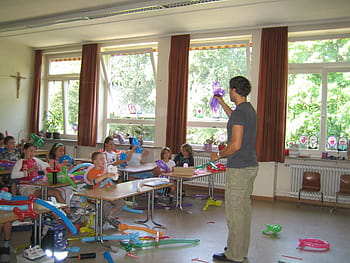 man, wearing, gray, crew-neck t-shirt, holding, purple, balloon, school, teaching, balloon knot, ballons
