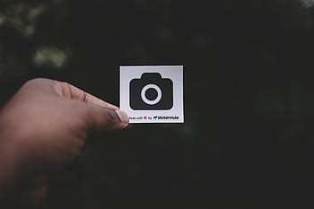 person, holding, white, black, camera print paper, dark, outside, hand, logo, graphics, human hand